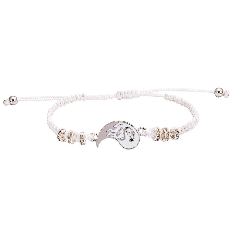 White beaded bracelet with a silver yin yang charm on a white background