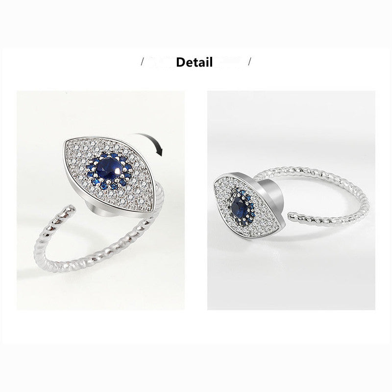 Silver eye-shaped ring with blue gemstone on a white background