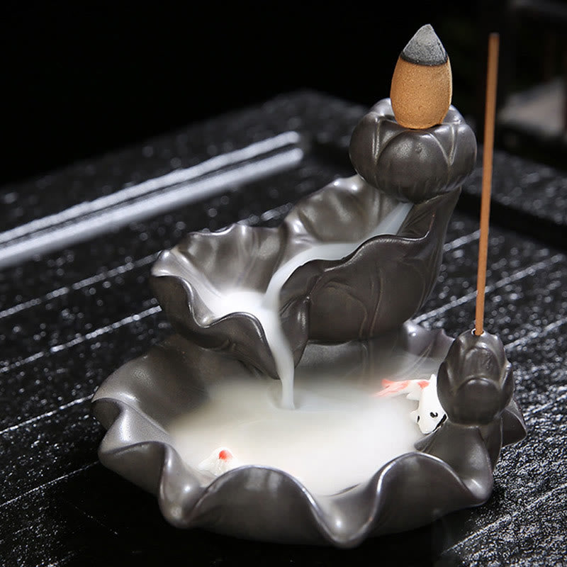 Ceramic incense burner with incense sticks on a dark surface