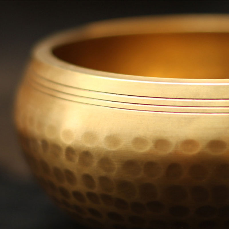 Close-up of a textured gold bowl on a dark background