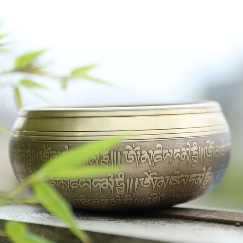 Decorative bowl with engraved text on a blurred natural background