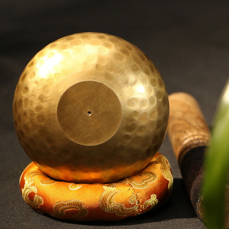 Gold gong on a decorative stand with a dark background