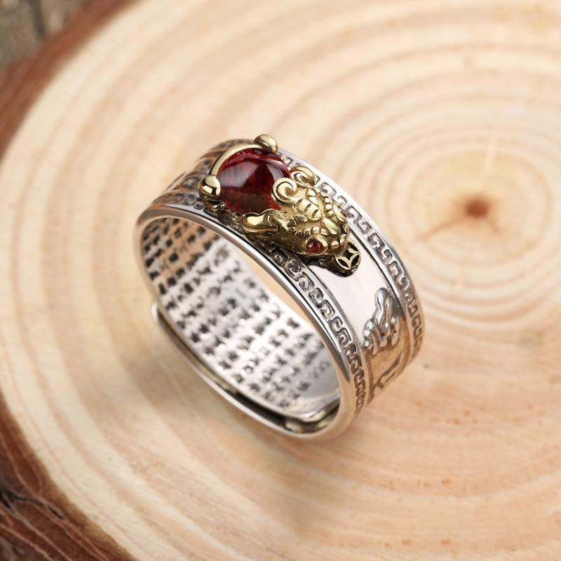 Decorative ring with a red gemstone on a wooden surface