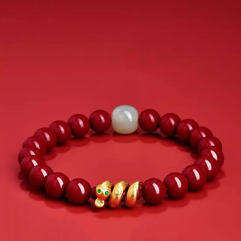 Red beaded bracelet with a gold charm on a red background