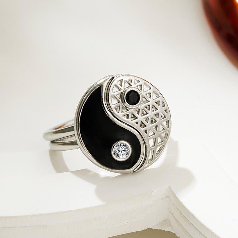 Silver ring with black and white design on a white surface