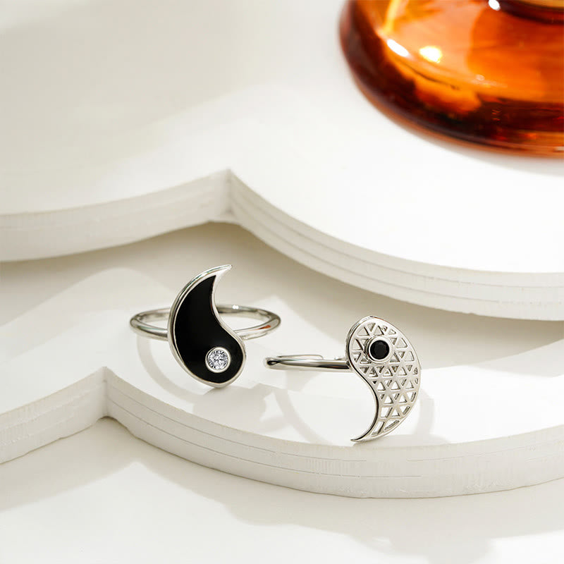 Two silver rings with black accents on a white surface