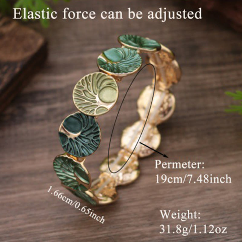 Decorative headband with green leaf-like designs on a wooden surface, showing elastic force adjustment and measurements.