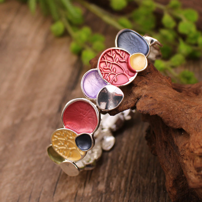Colorful bracelet with circular, embossed designs on a wooden surface