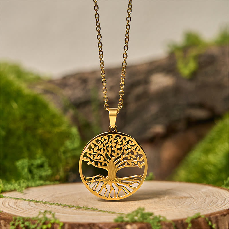 Gold tree-shaped pendant necklace on a wooden stump with a natural background