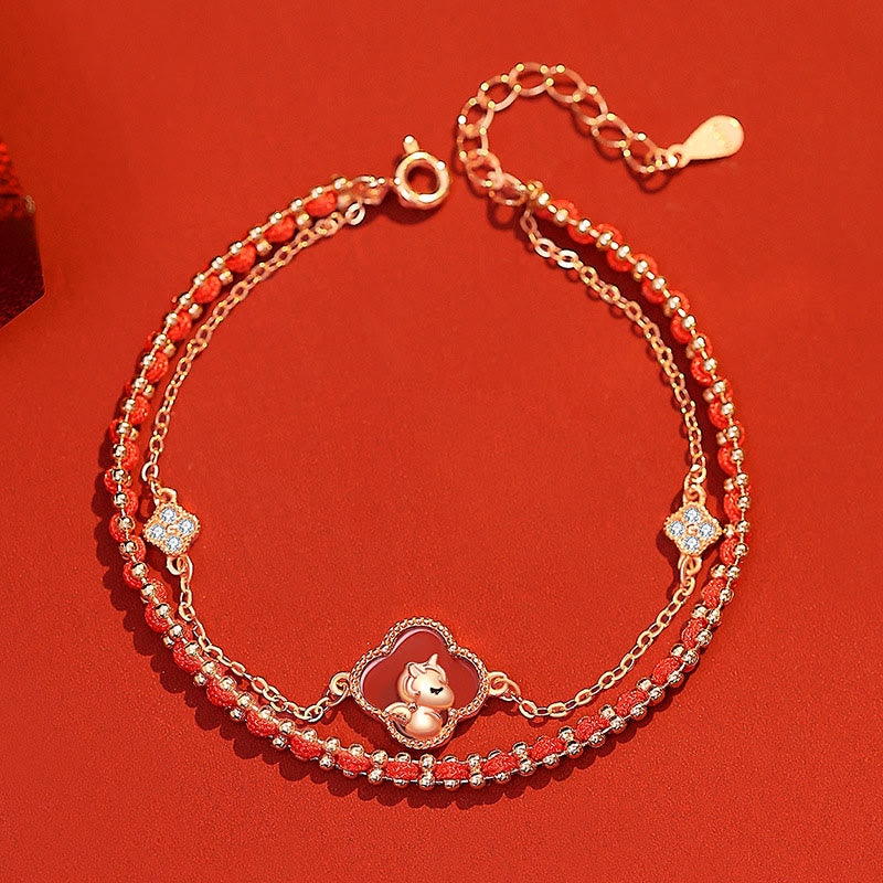 Gold bracelet with red beads on a red background