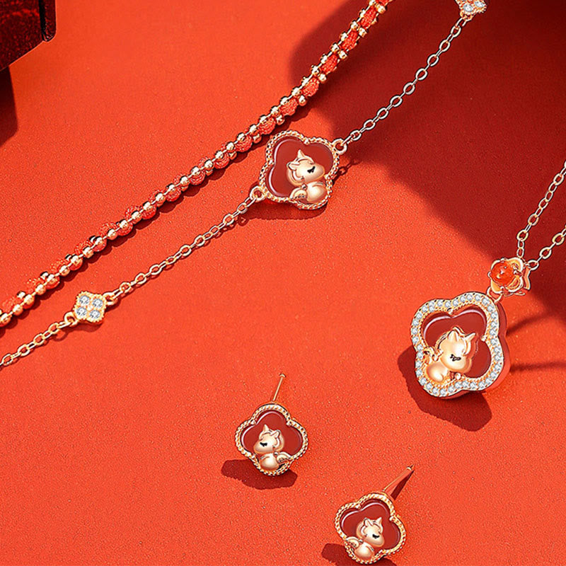 Jewelry set with cat-themed pendants on a red background