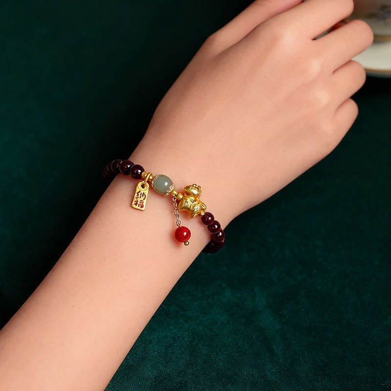 Bracelet with charms on a wrist against a dark background