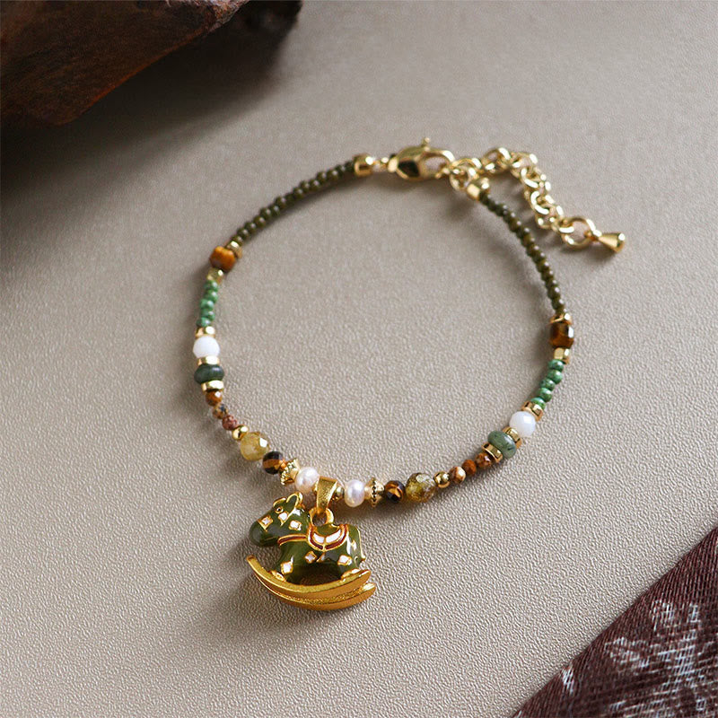 Beaded bracelet with a gold charm on a neutral background