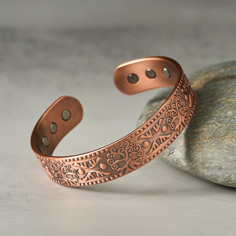 Copper bracelet with intricate patterns on a stone surface