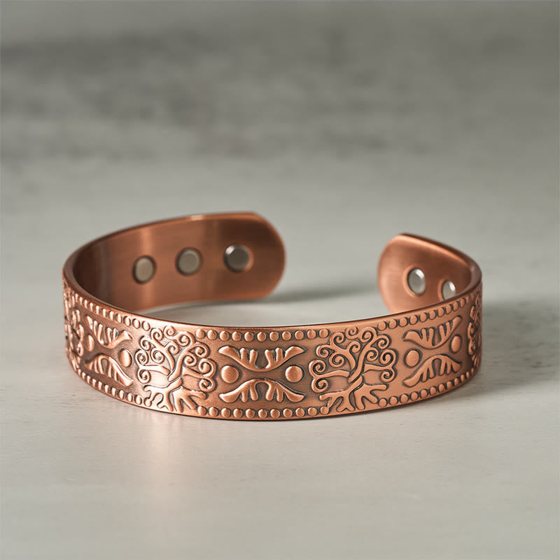 Copper bracelet with intricate patterns on a gray background