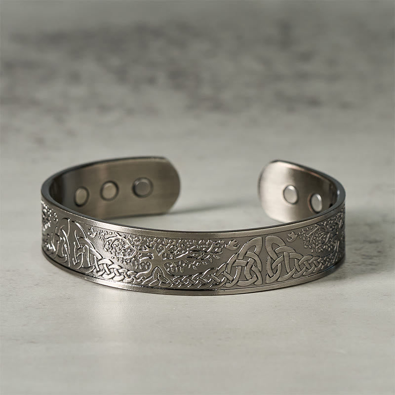 Silver bracelet with intricate designs on a gray background