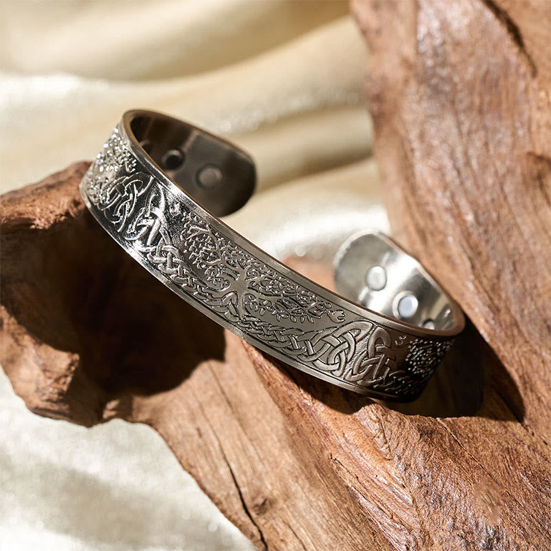 Silver bracelet with intricate designs on a wooden surface