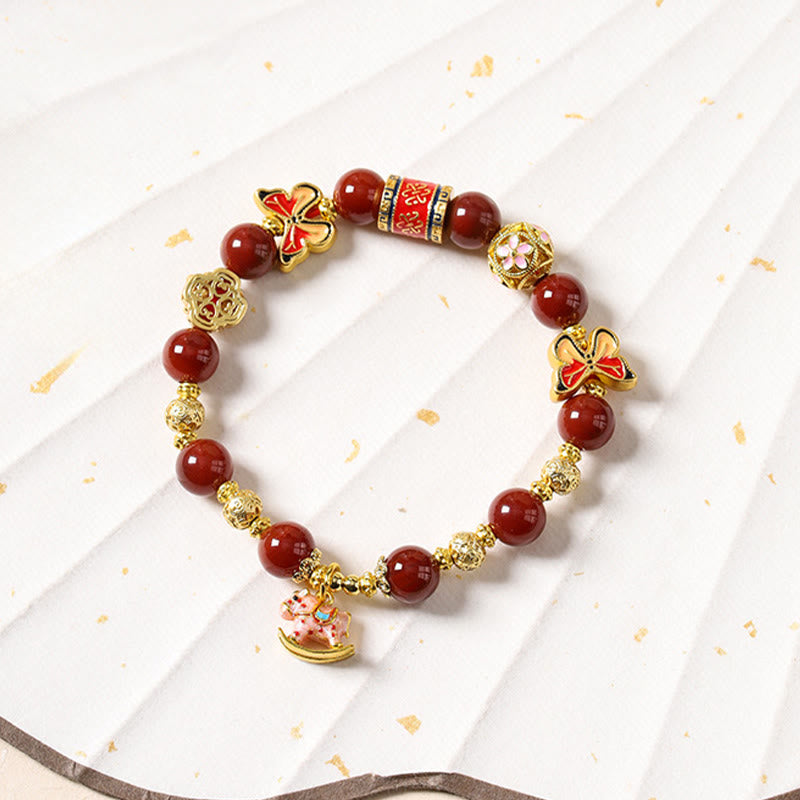 Bracelet with red beads and gold accents on a white background