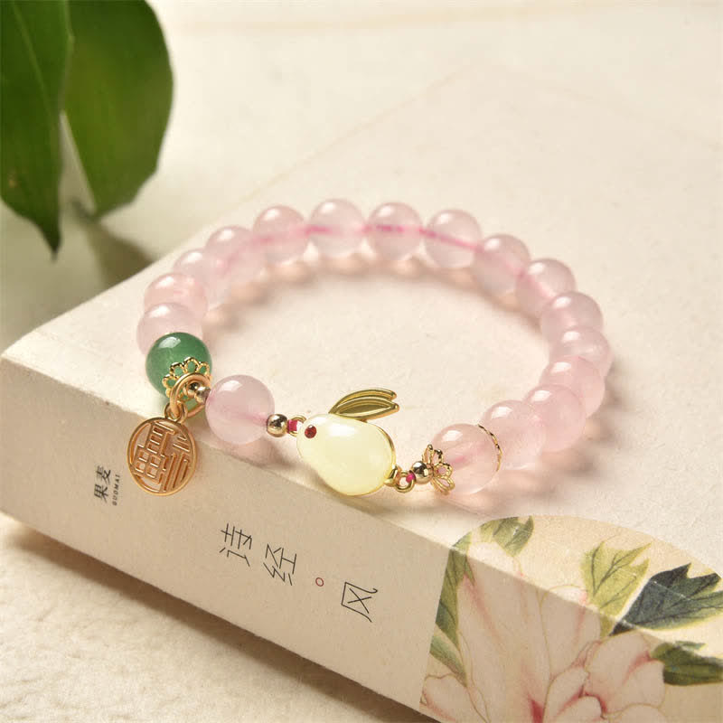 Pink beaded bracelet with decorative elements on a floral box