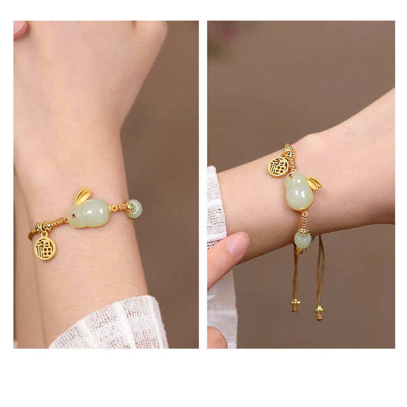 Bracelet with green beads and gold accents on a wrist against a neutral background