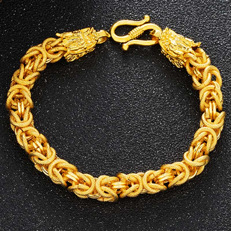 Gold bracelet with dragon design on a black background