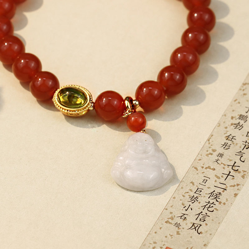 Bracelet with red beads and a white jade pendant on a textured surface