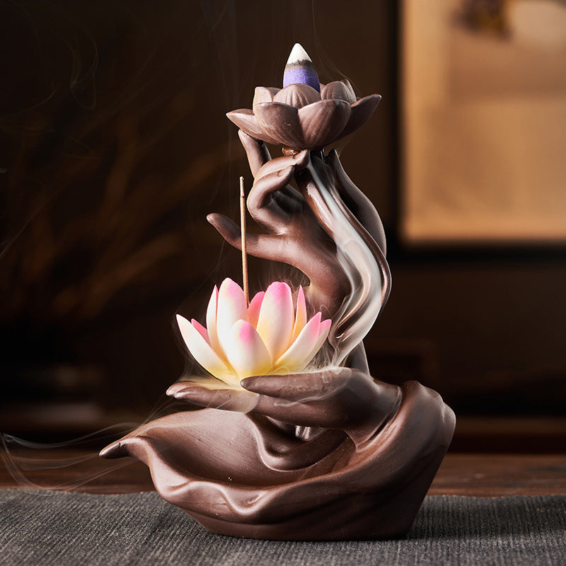 Ceramic incense burner with lotus design on a dark surface