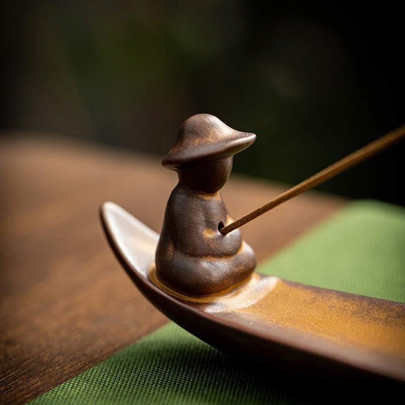 Incense burner with a single incense stick on a wooden surface