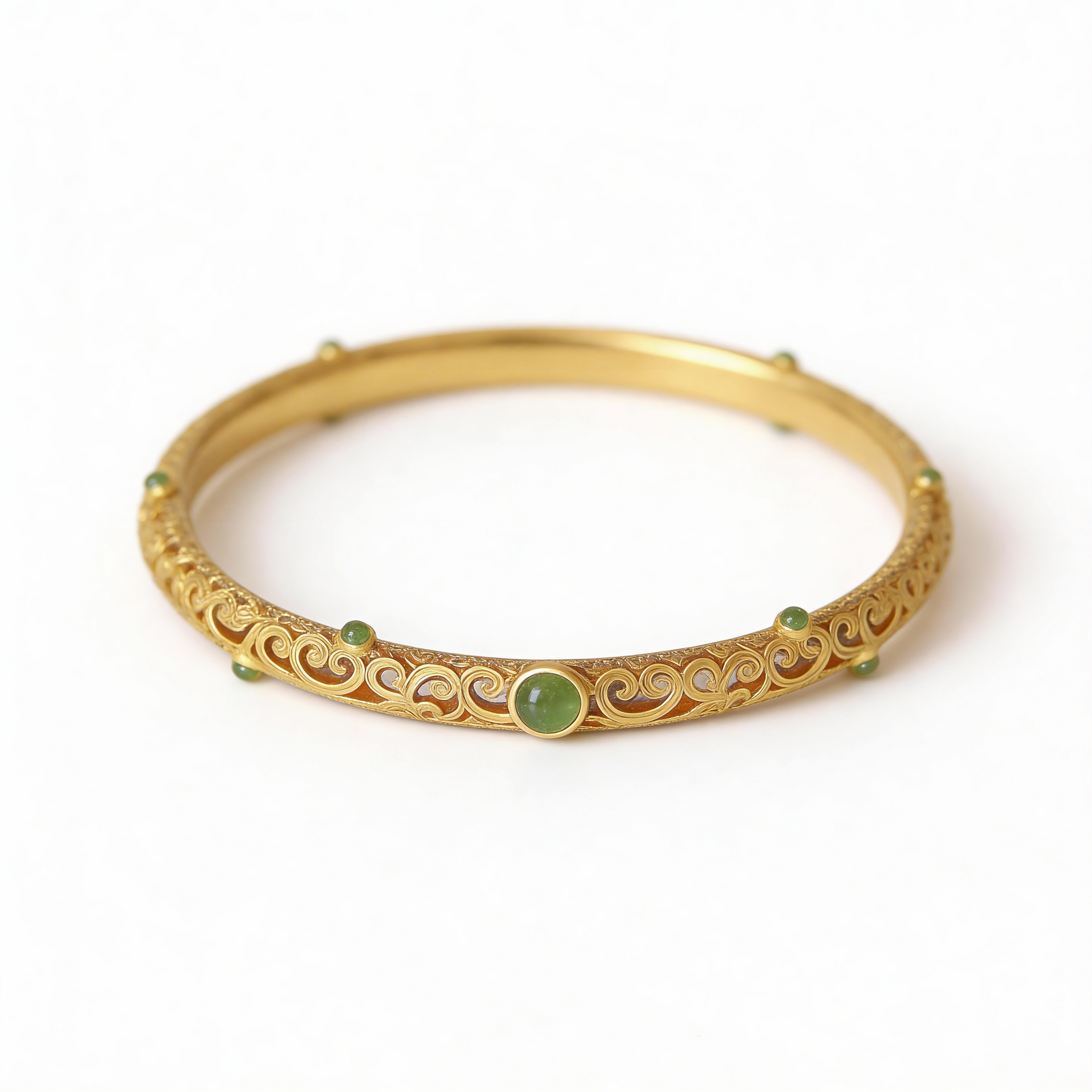Gold bracelet with green stones on a white background