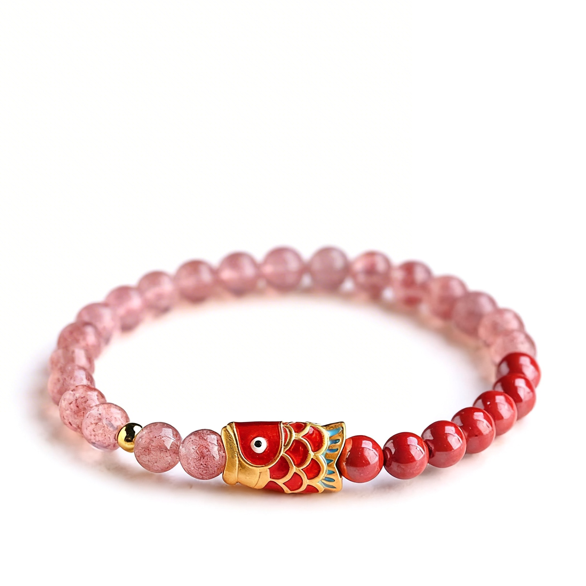 Bracelet with red and gold fish charm and pink beads on a white background