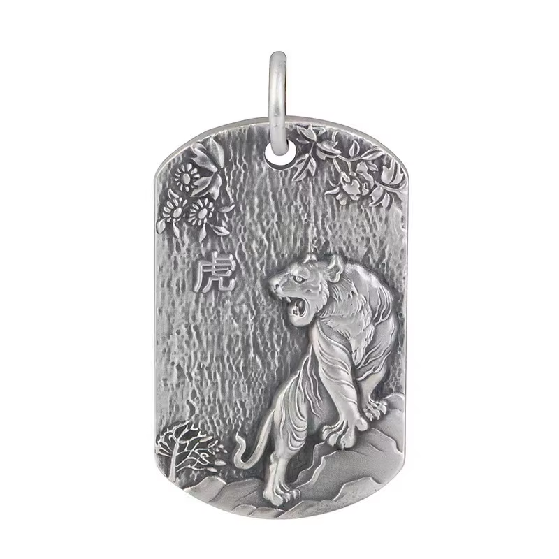 Silver pendant with a tiger design on a white background