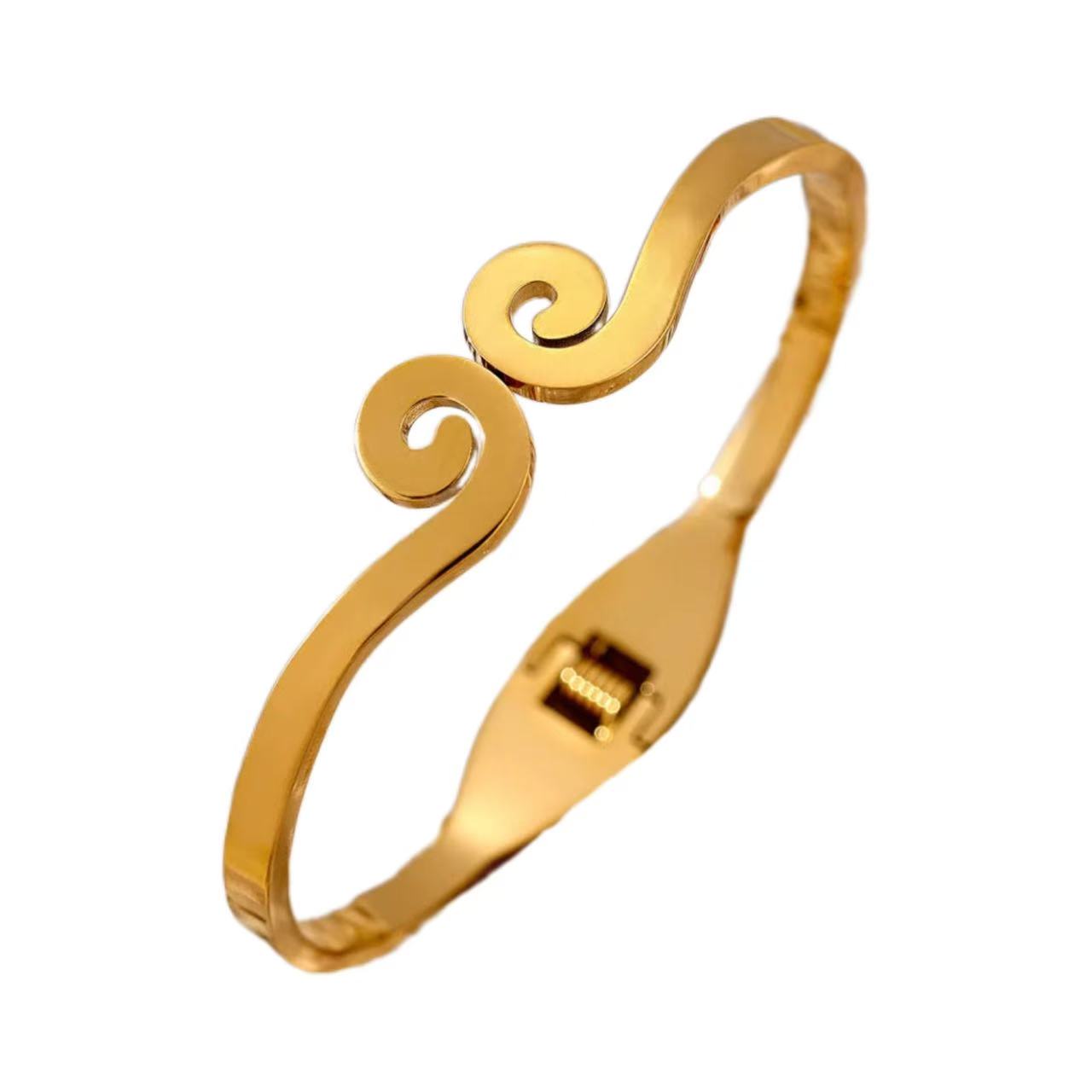 Gold bracelet with spiral design on a white background