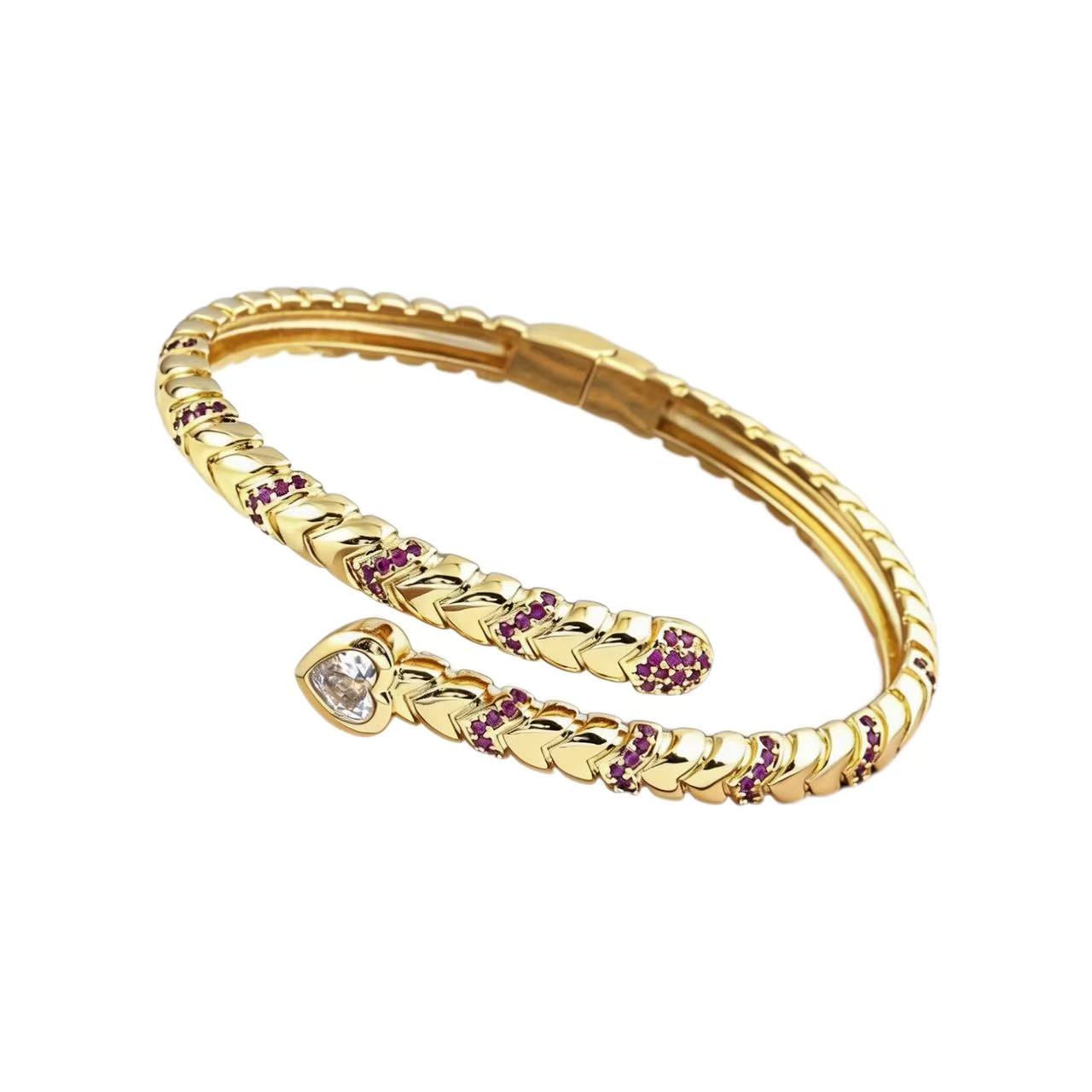 Gold bracelet with heart-shaped gemstone and purple stones on a white background
