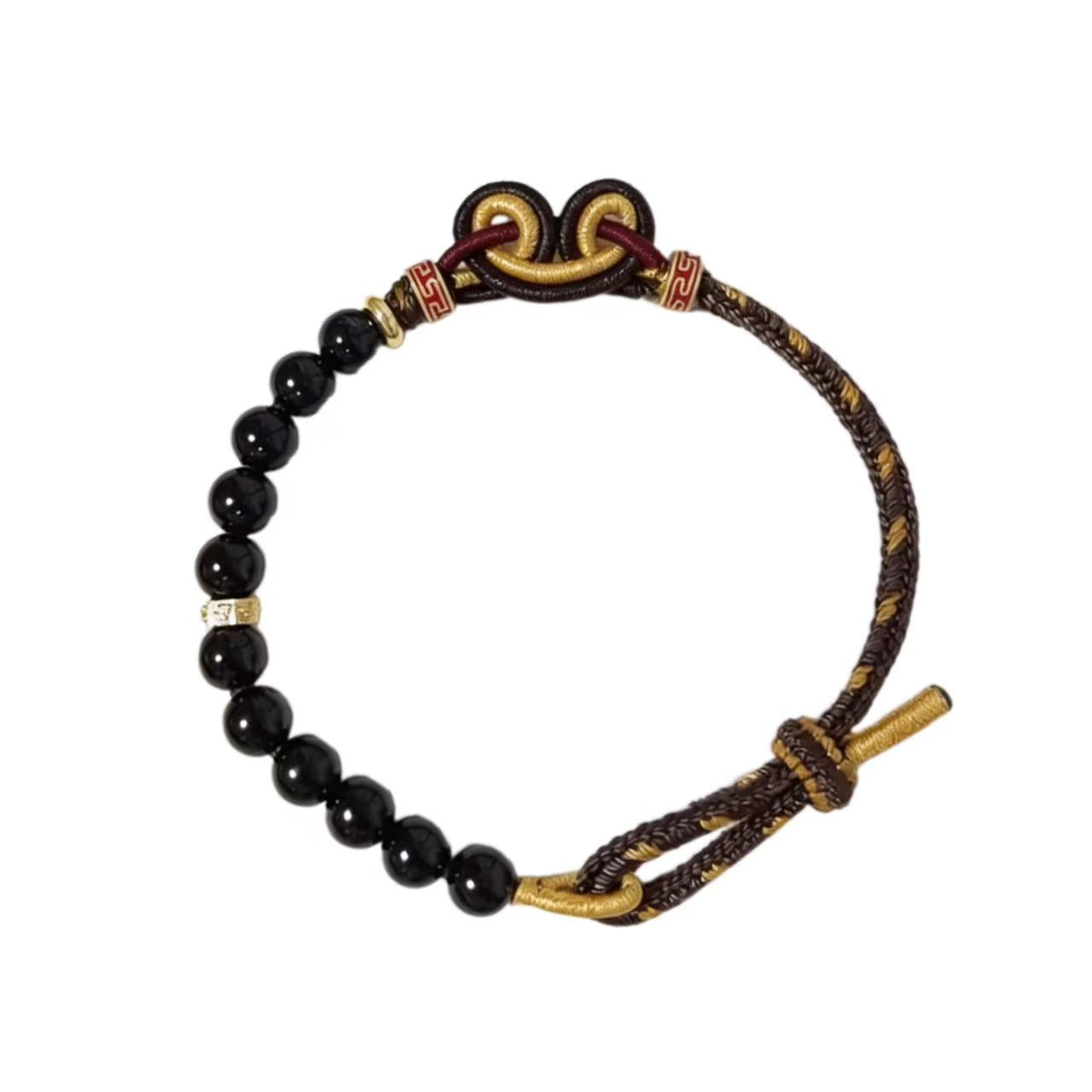 Bracelet with black beads and gold accents on a white background