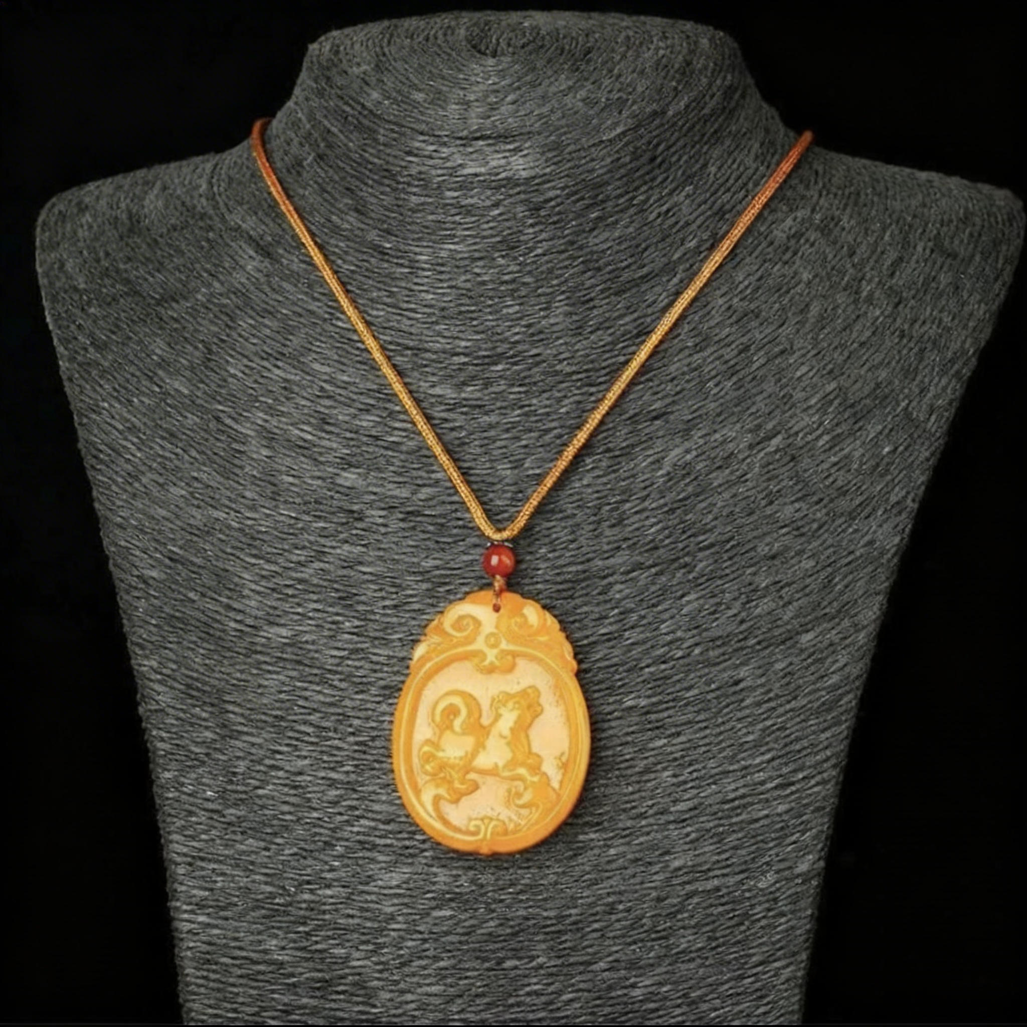 Gold necklace with a pendant on a gray mannequin