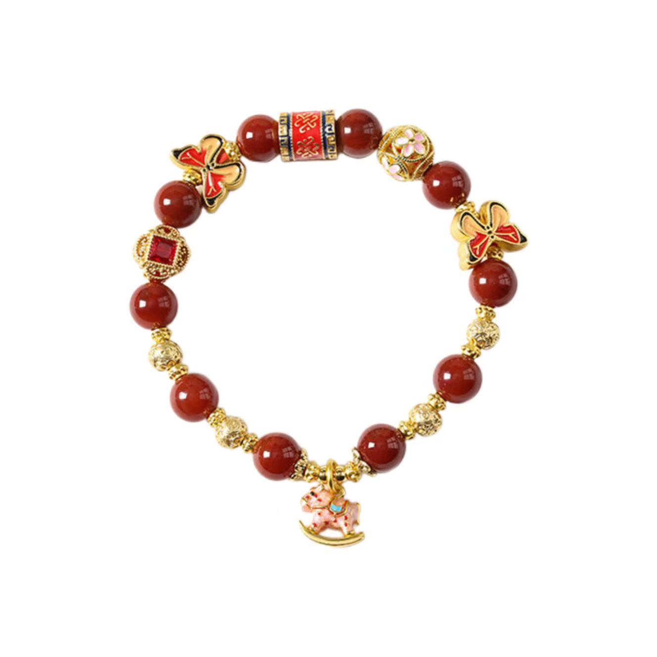 Bracelet with red beads and gold accents on a white background