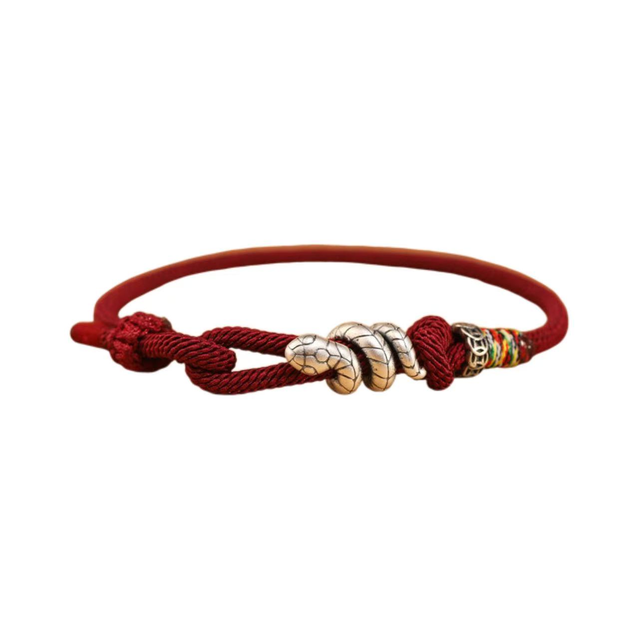 Red braided bracelet with metallic and colorful beads on a white background