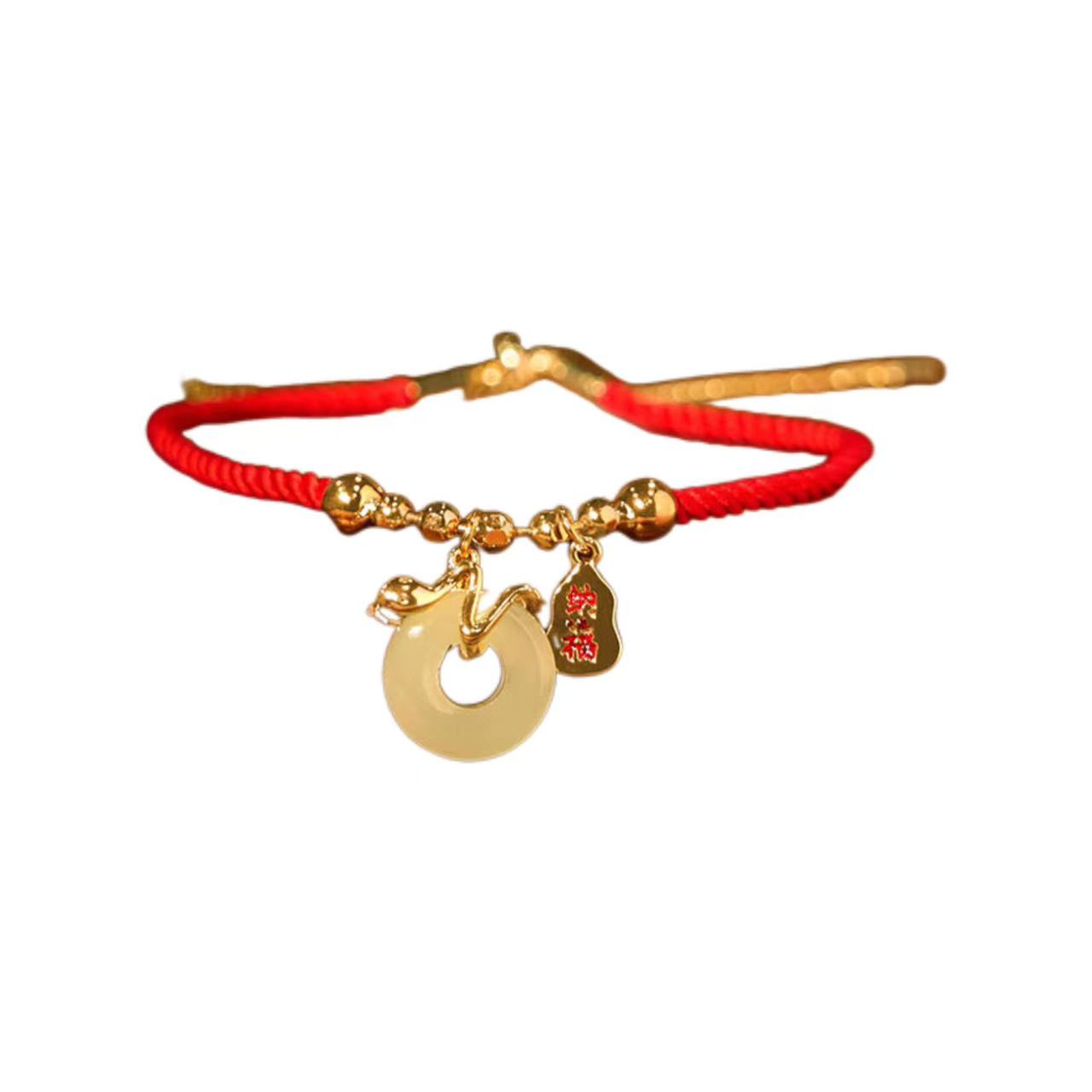 Bracelet with gold charms and red cord on a white background