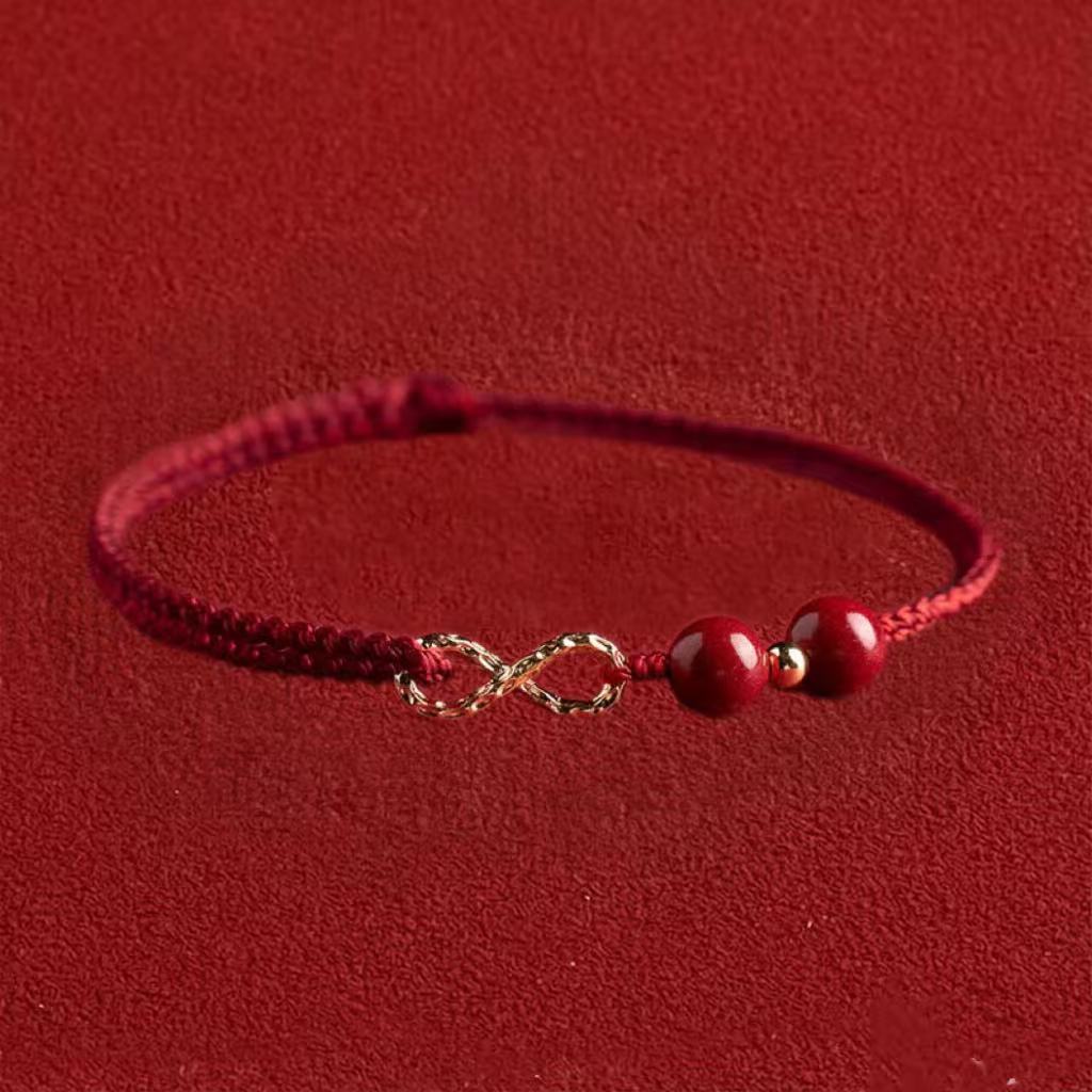Red bracelet with a gold infinity symbol charm on a red background