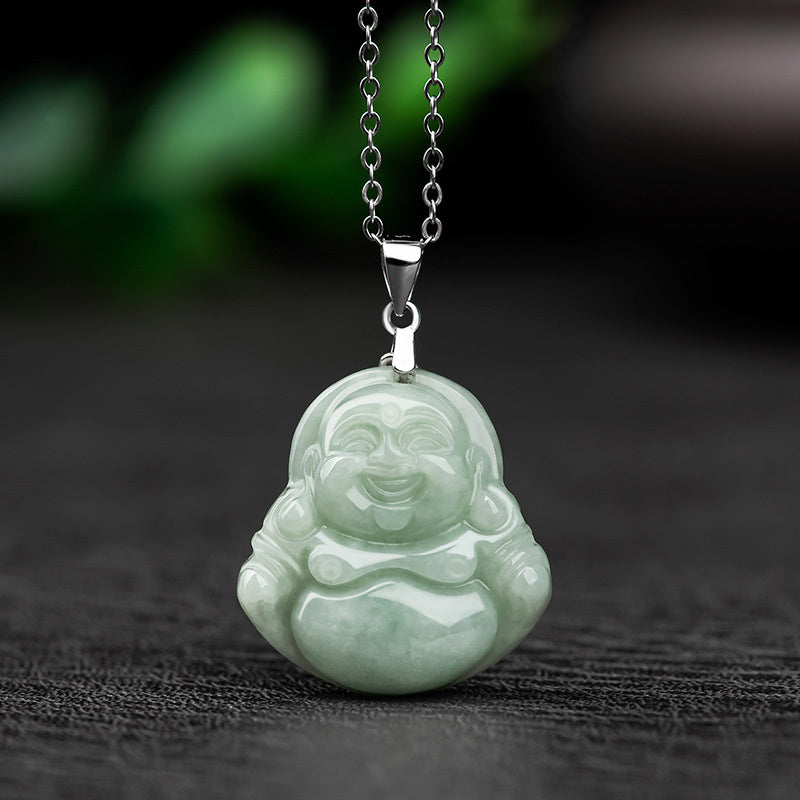 Green jade Buddha pendant on a chain against a dark background