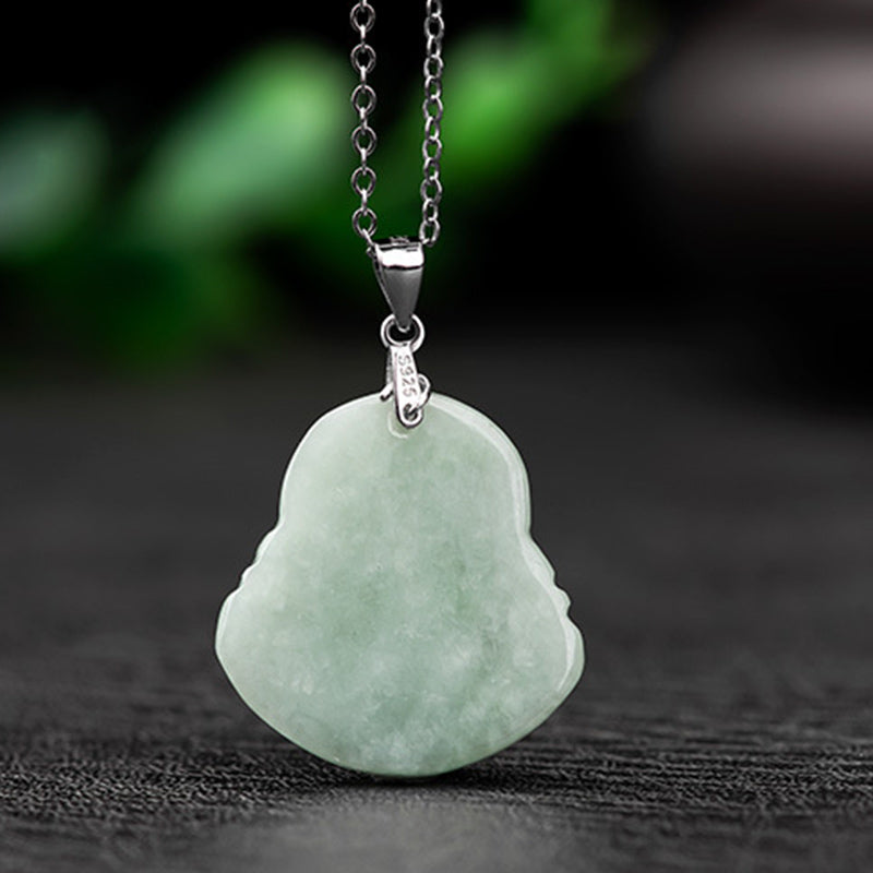 Green jade pendant on a chain against a dark background