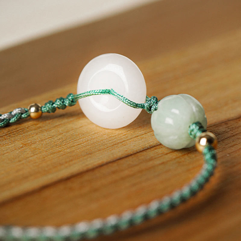 Bracelet with white and green beads on a wooden surface