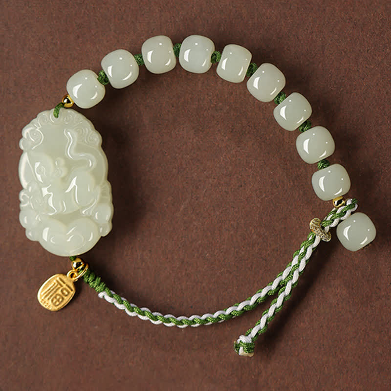 Jade bracelet with a carved pendant on a brown background