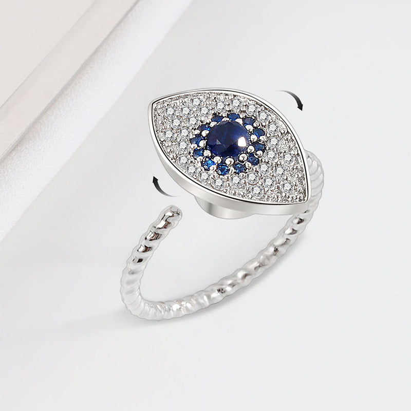 Silver ring with a blue gemstone and diamond accents on a white surface