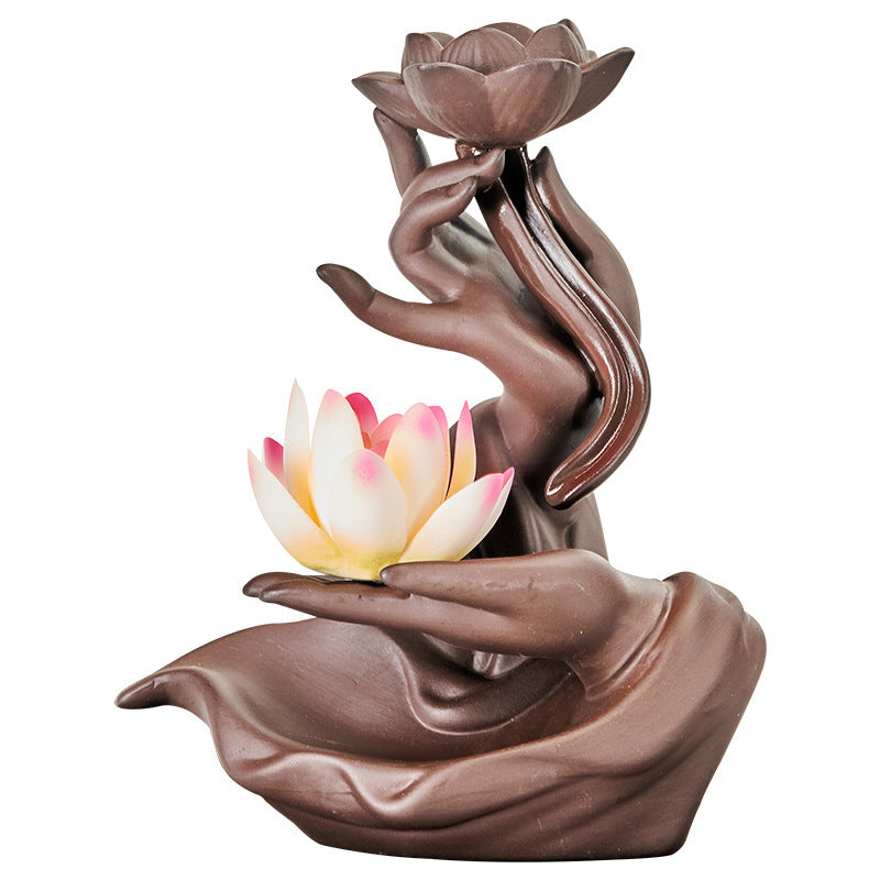 Decorative sculpture of hands holding lotus flowers on a white background