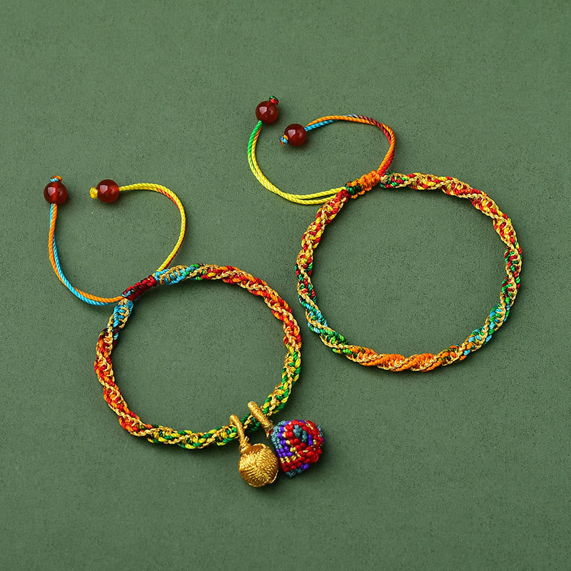 Colorful braided bracelets with decorative elements on a green background