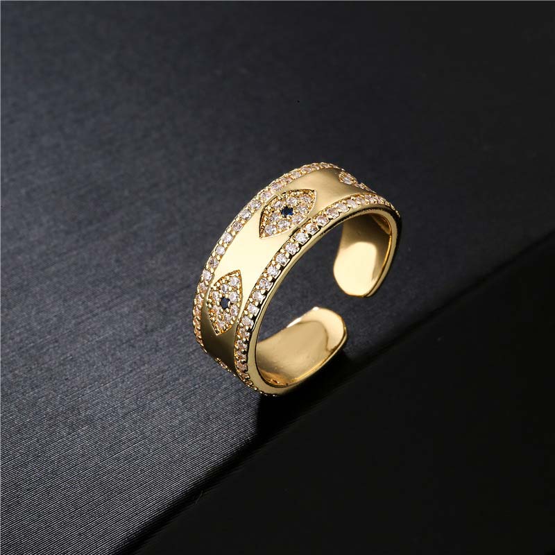 Gold ring with intricate design on a dark textured background