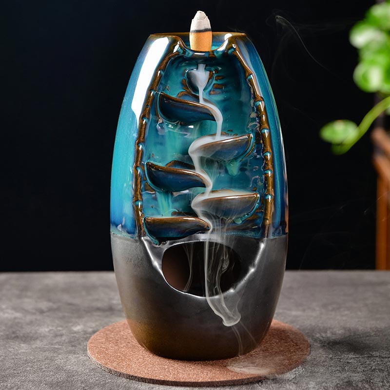 Ceramic incense burner with blue and black design on a dark background