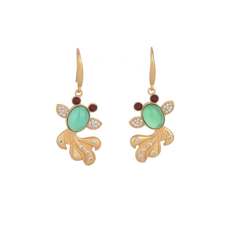 Gold earrings with green gemstones on a white background