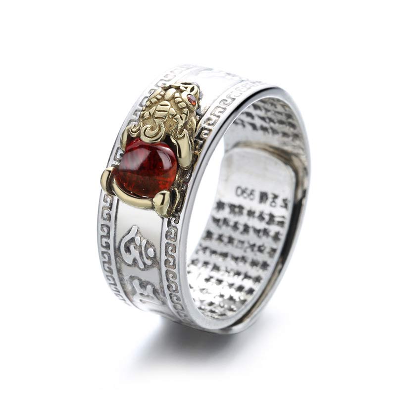 Silver ring with a red gemstone and gold accents on a white background